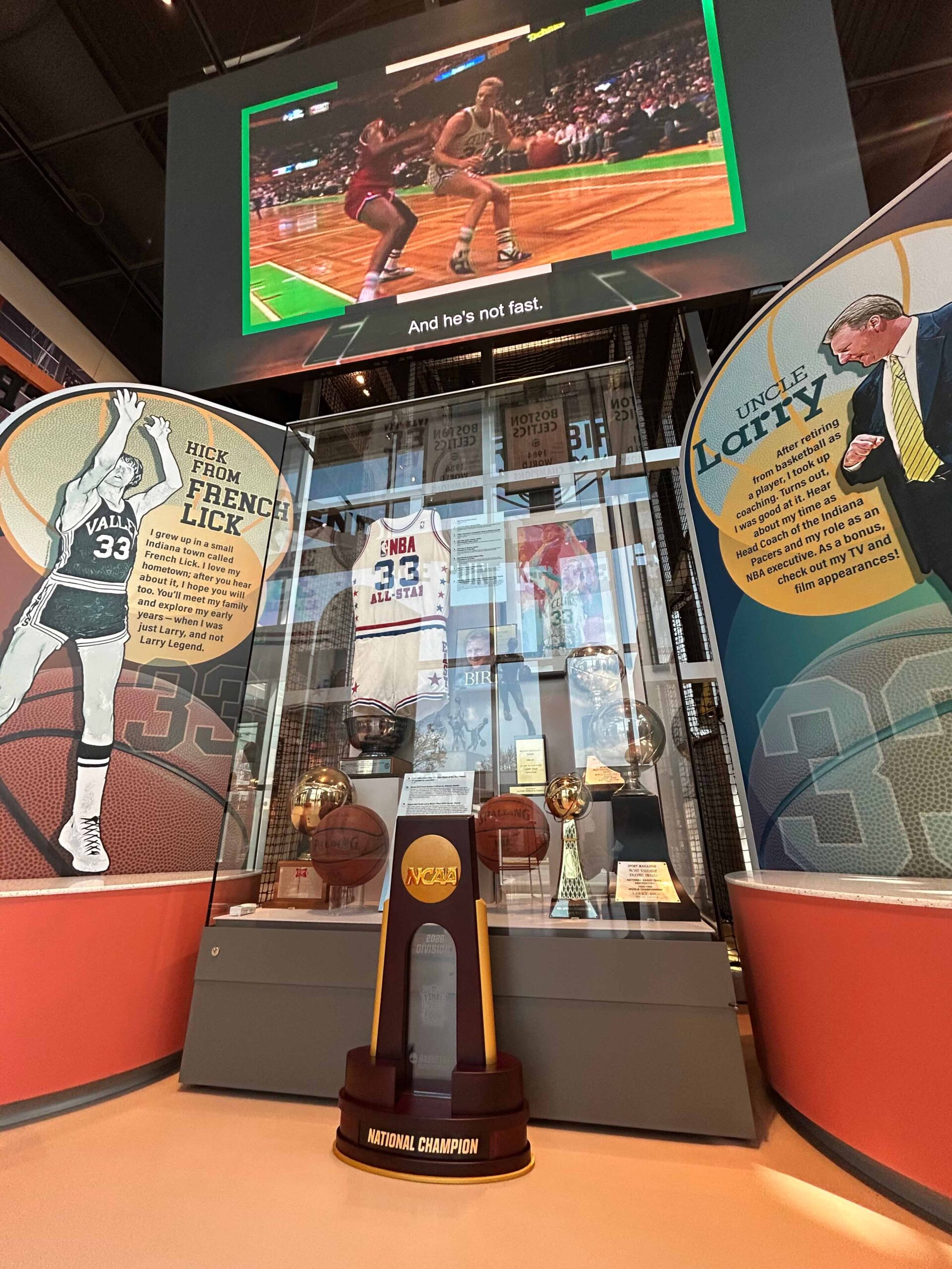 The 2026 NCAA Men's Final Four trophy in front of an exhibit at the Larry Bird Museum.