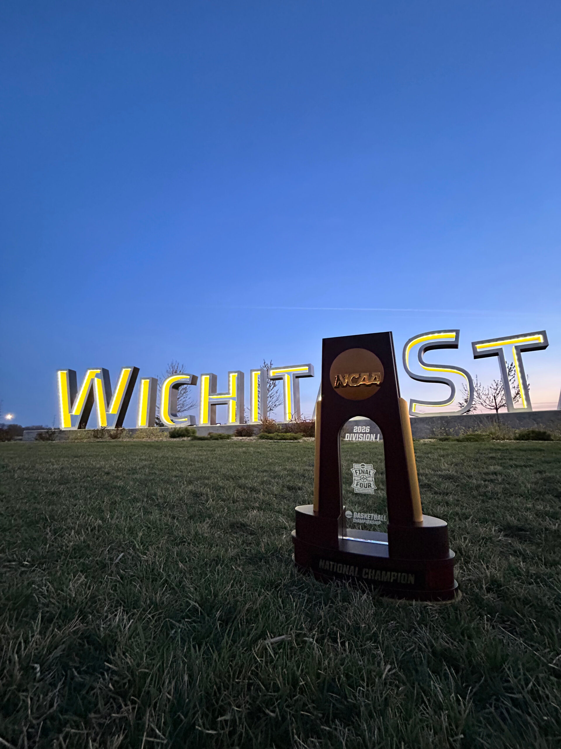The 2026 NCAA Men's Final Four trophy in front of a sign at Wichita State University.